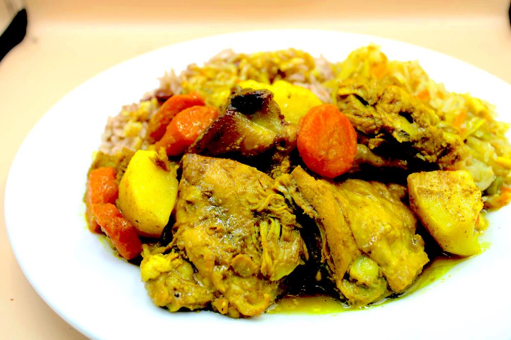 Curried chicken with potato and carrot over rice and peas