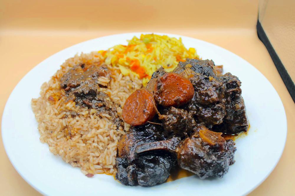 Brown stew oxtail plate with rice and peas